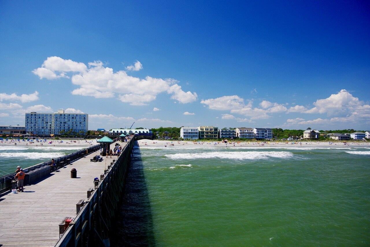 The view south along the wide sandy shore from Folly Beach pier near Charleston, South Carolina.