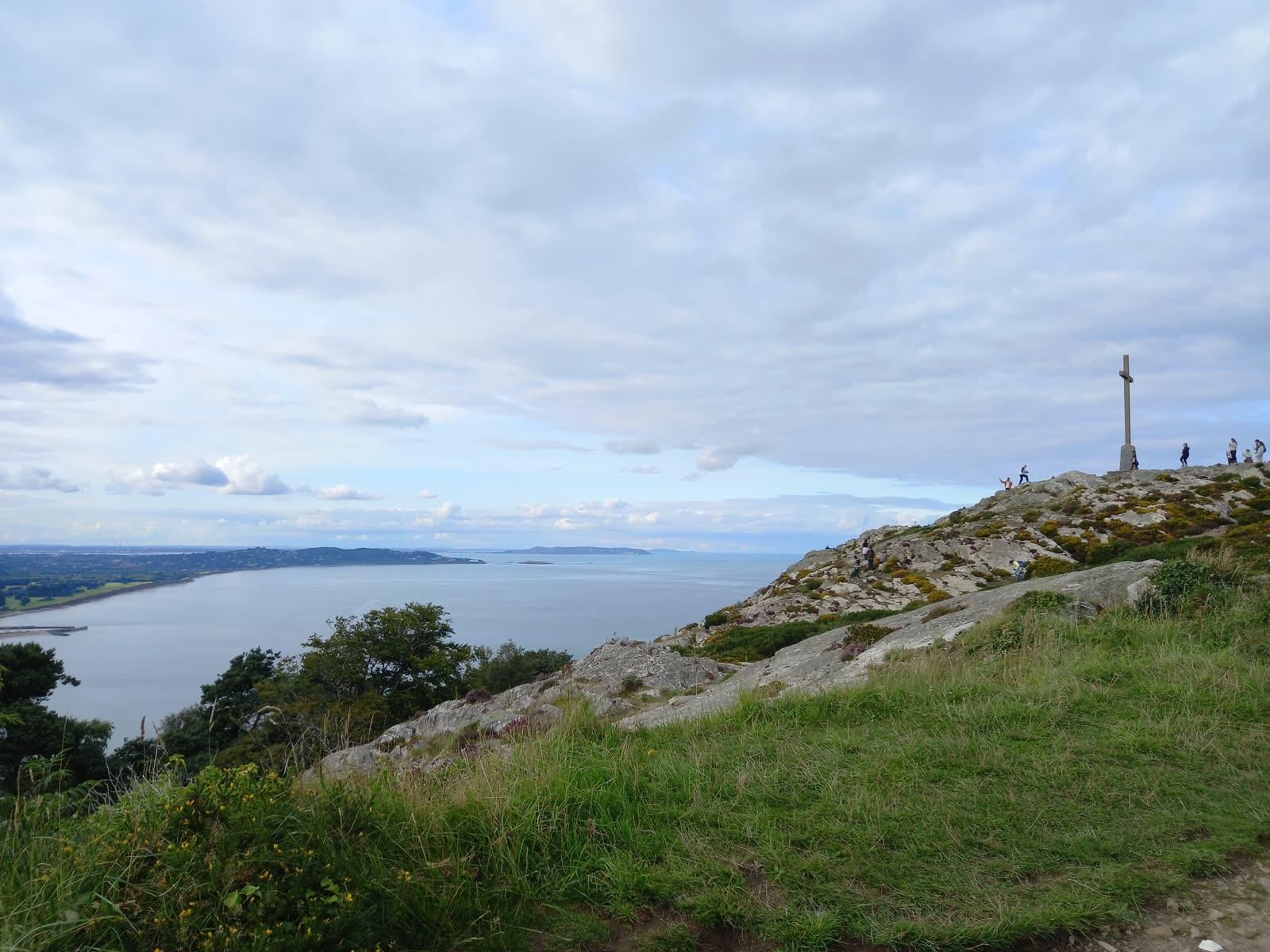 The white summit cross on the rocky crest of Bray Head with the sea and the Wicklow coast behind