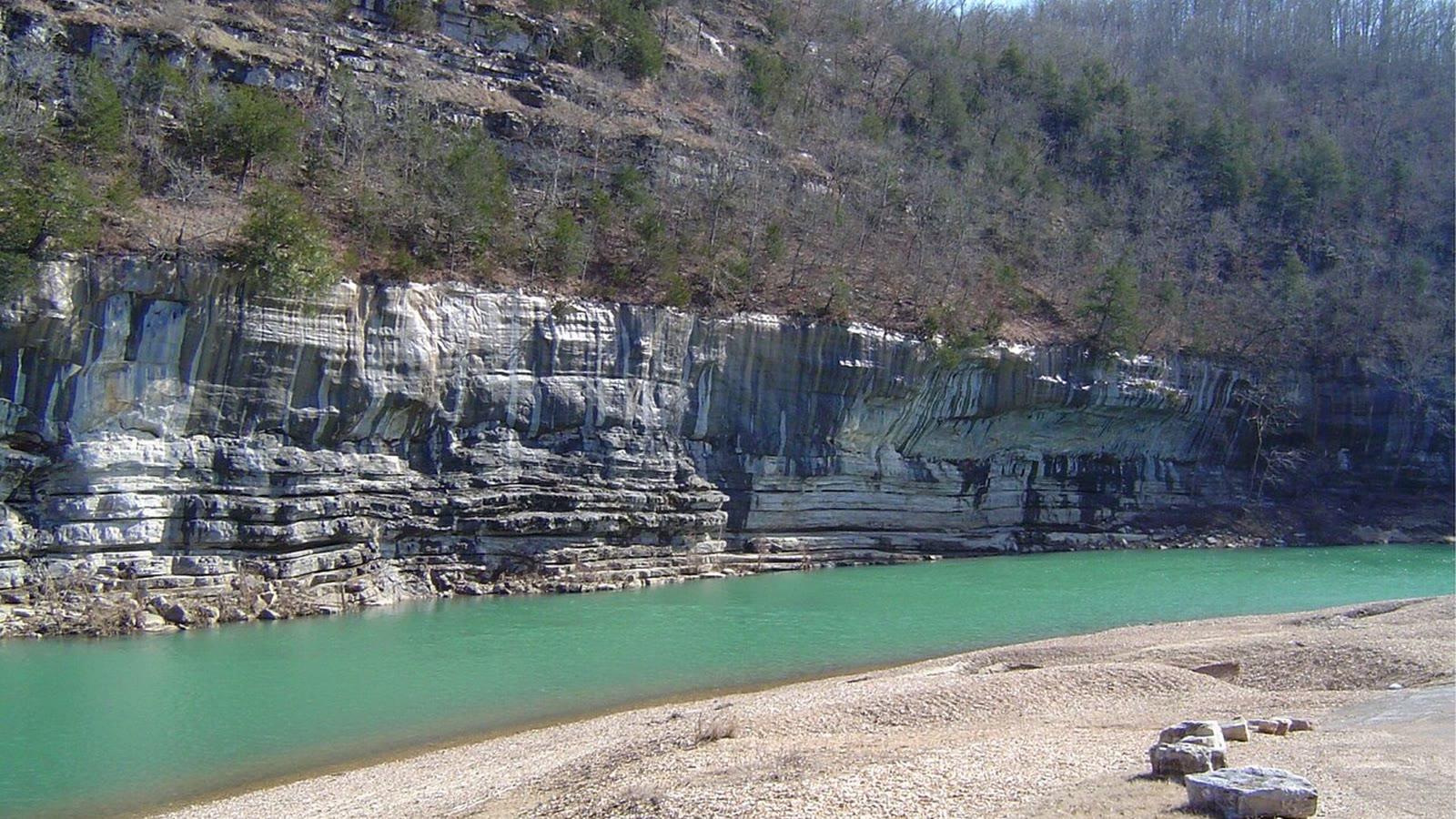 A gravel bar on the Buffalo River with a layered limestone bluff forming the far bank at Buffalo Point