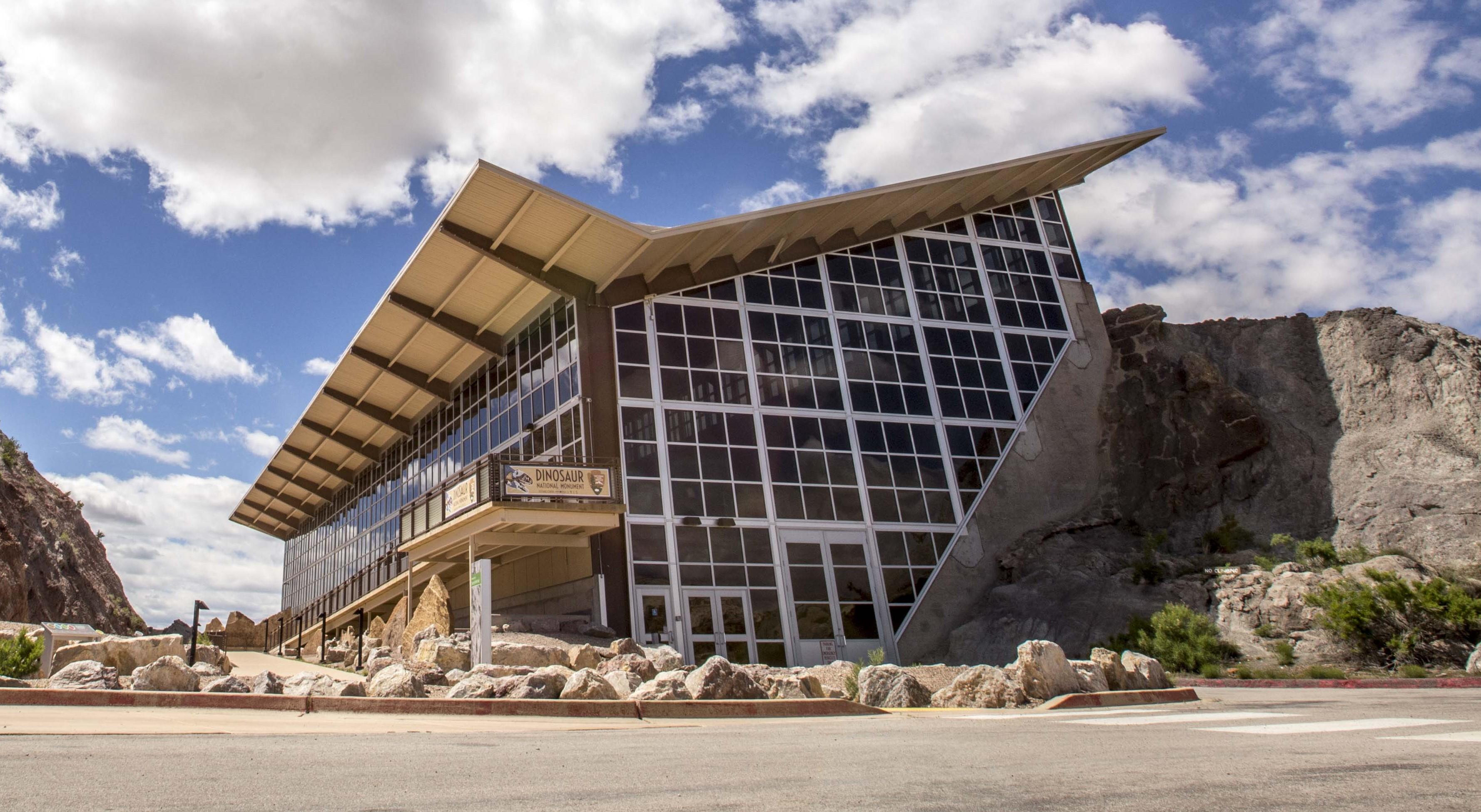 Glass-walled Quarry Exhibit Hall building set against the rocky cliffside at Dinosaur National Monument, Utah.