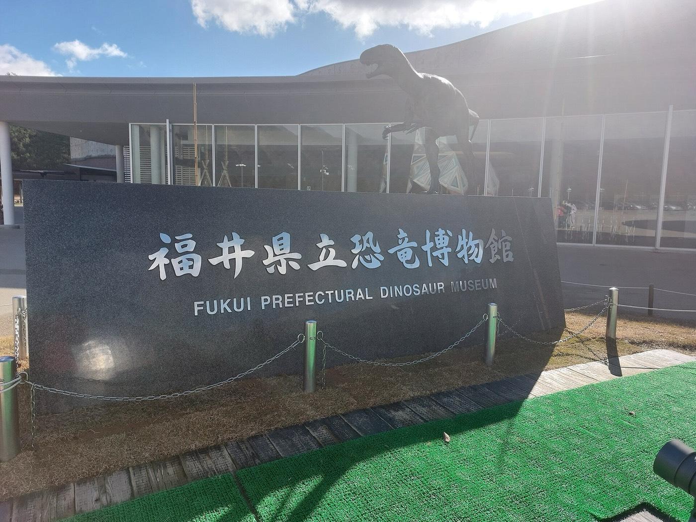 The Fukui Prefectural Dinosaur Museum at night, its dome lit against the dark