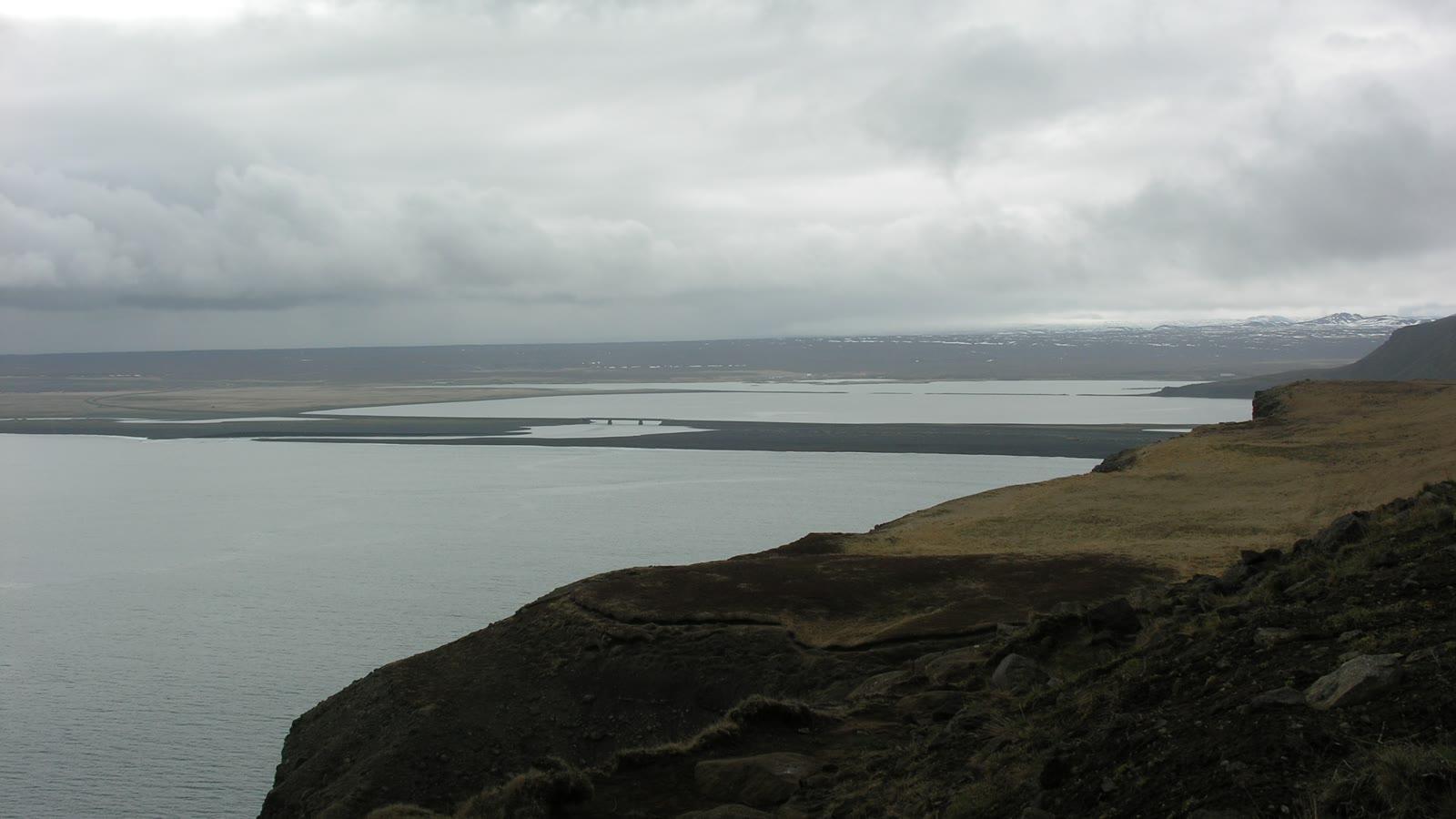 The coastal cliffs and grassy headland of the Tjörnes peninsula above a grey northern sea