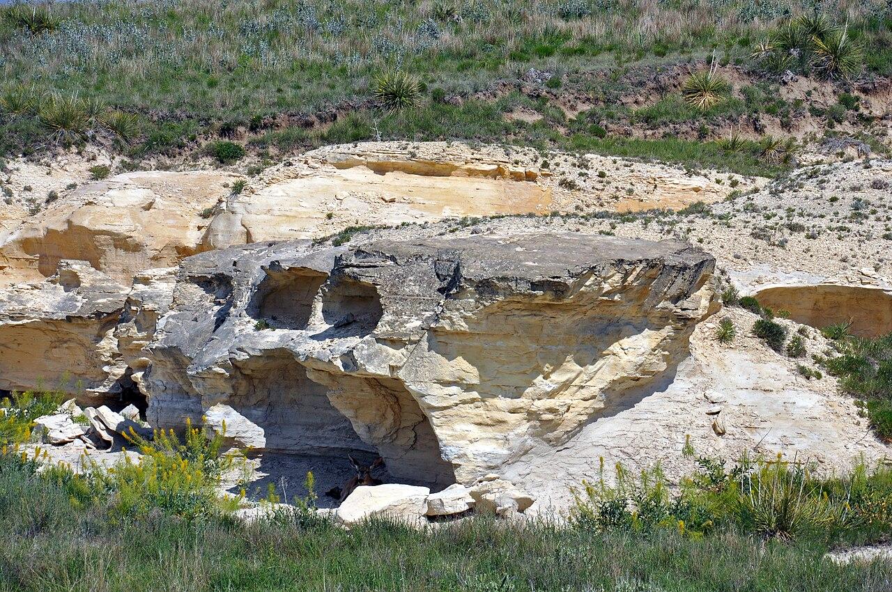 Pale chalk badlands of the Niobrara Formation eroded into low bluffs under a wide sky
