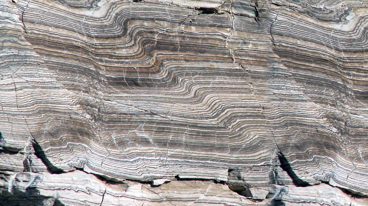 Tightly folded bands of pale gypsum rock, the layers buckled into tight waves