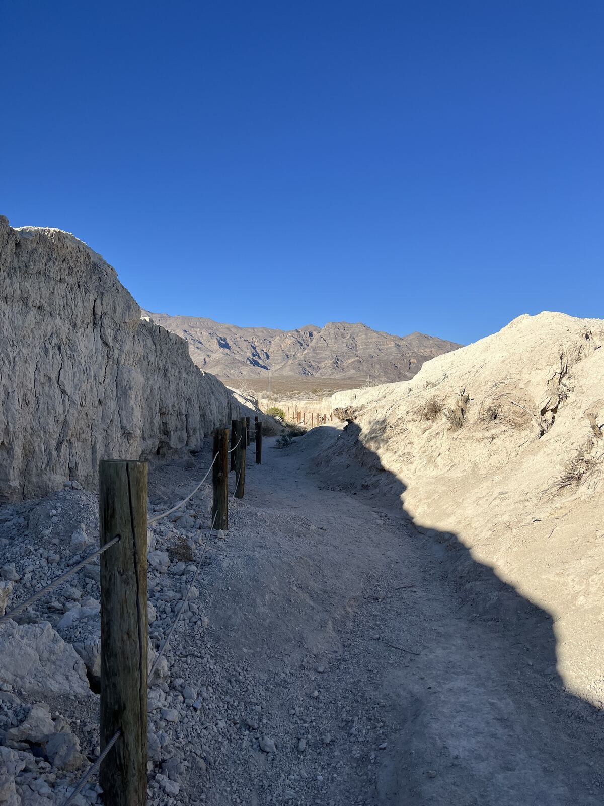Trail and interpretive plaques leading into the pale desert badlands at Tule Springs Fossil Beds National Monument, Las Vegas, Nevada.